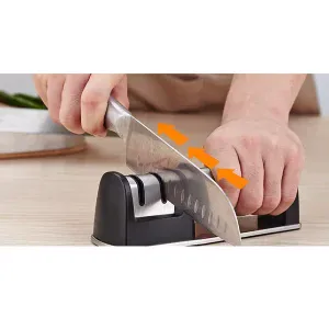 "Truper 15147 manual knife sharpener with two sharpening stages for precision. The sharpener features a durable plastic body, ergonomic handle, and two ceramic wheels for coarse and fine sharpening. Ideal for maintaining kitchen knives, it provides a secure, easy-to-use grip while restoring blade sharpness efficiently. Compact and portable design for convenient storage."