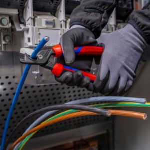Electrician using wire stripper tool at SAKR Building Materials.