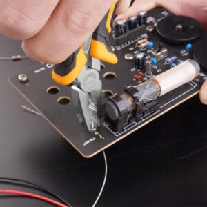 SAKR Building Materials electronic repair tools, precision pliers working on circuit board.