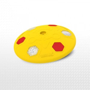 Yellow plastic speed bump with reflective red and white panels, used for traffic control and safety.