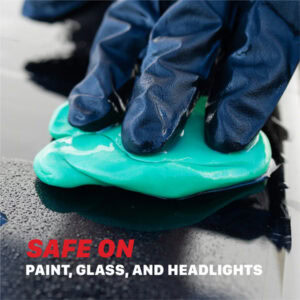 Close-up of a hand applying waterproof sealant on a building surface with gloves.