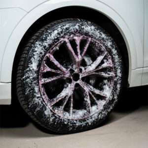 Alloy wheel with snow and ice, close-up of vehicle tire and rim.