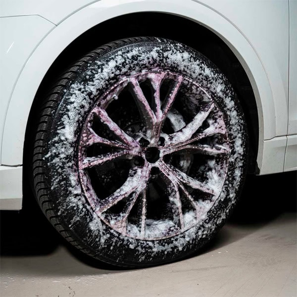 Alloy wheel with snow and ice, close-up of vehicle tire and rim.