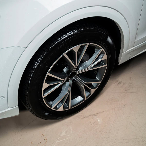Luxury car wheel with alloy rim and tire, close-up shot.