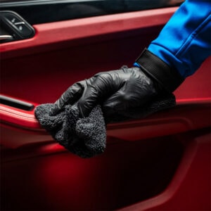 Car interior cleaning with microfiber cloth and gloves for a spotless finish.