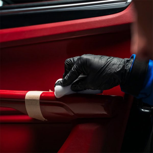 Interior car cleaning using protective gloves and a cleaning cloth.