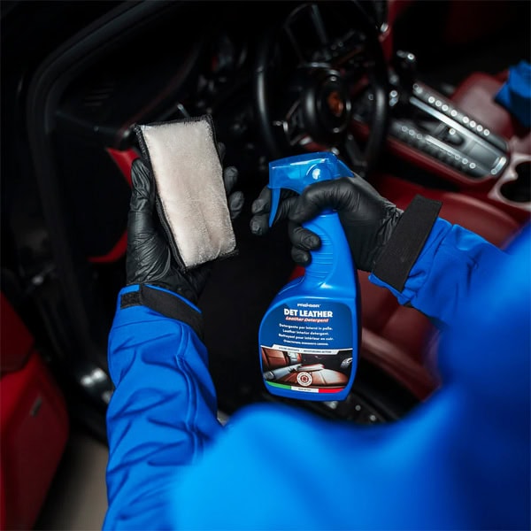 Car interior cleaning with spray and cloth, professional detailing tools.