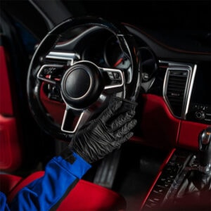 Steering wheel cleaning glove in a car interior, highlighting vehicle maintenance and hygiene practi.