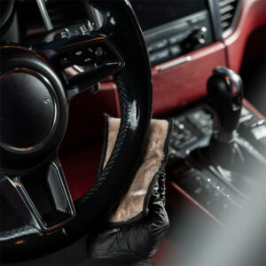 Interior cleaning of a vehicle with disinfectant cloth and protective gloves.