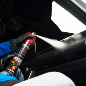 Fireproof spray being applied to a vehicle interior for fire protection.