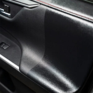 Close-up of a car dashboard surface showing textured black material.