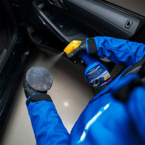 Professional car interior cleaning using spray and cloth for hygiene and maintenance.