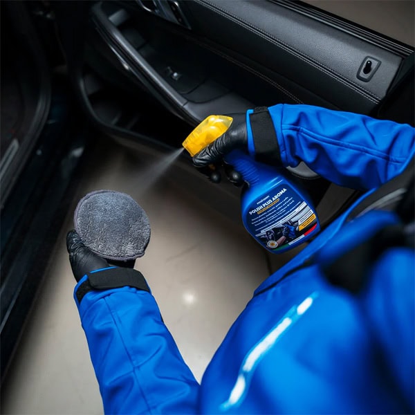 Professional car interior cleaning using spray and cloth for hygiene and maintenance.