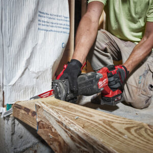 Construction worker using power saw on wooden beam at Sakr Building Materials.