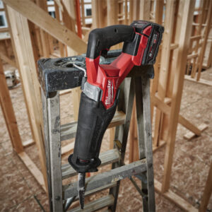 Cordless power drill resting on ladder at construction site for building materials.